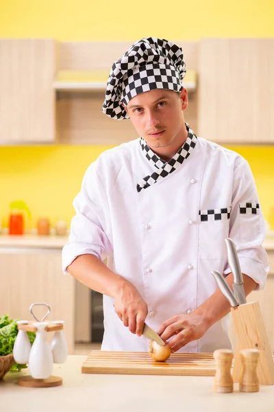 Joven cocinero profesional preparando ensalada en la cocina — Foto de Stock