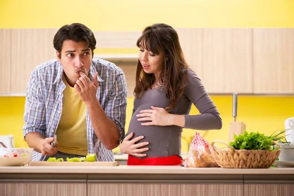 Hombre y mujer embarazada preparando ensalada en la cocina — Foto de Stock