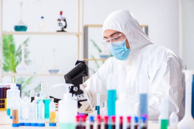 Laboratuvarda kimyasallar üzerinde çalışan genç bir kimyager.