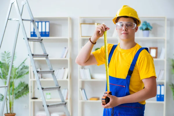 Young contractor doing repair works at office — Stock Photo, Image