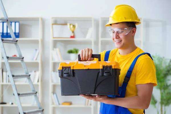 Jovem empreiteiro fazendo obras de reparação no escritório — Fotografia de Stock