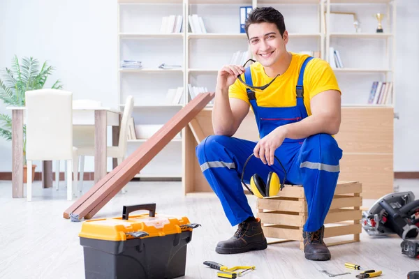 Young contractor doing repair works at office — Stock Photo, Image