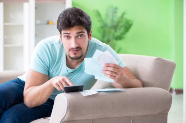 Genç adam kişisel finans ve faturalarla boğuşuyor.