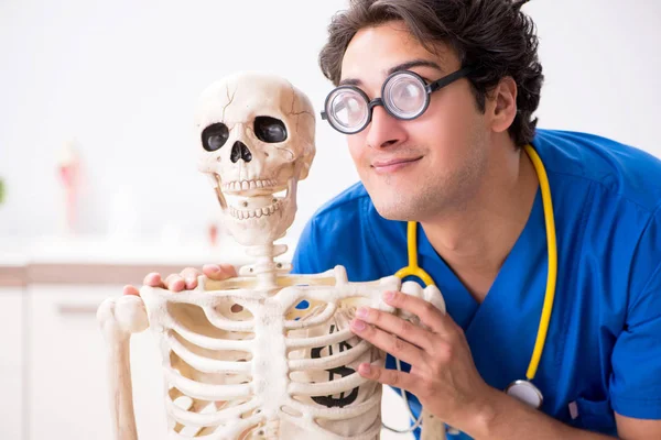 Смешной доктор со скелетом в больнице — стоковое фото
