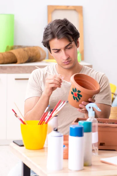 Молодой человек украшает керамику в классе — стоковое фото