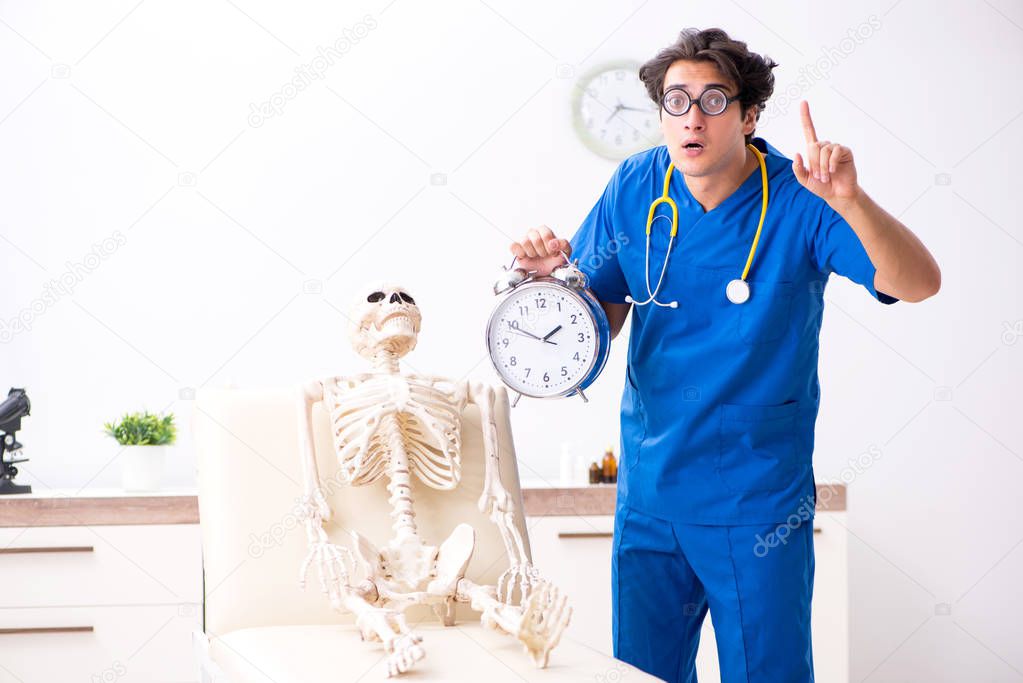 Funny doctor with skeleton in hospital