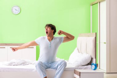 Genç adam sabahın köründe uyanmakta zorlanıyor.