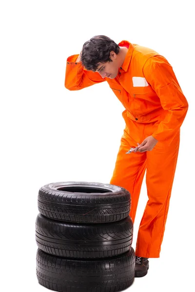 Jovem trabalhador de garagem com pneu isolado em branco — Fotografia de Stock