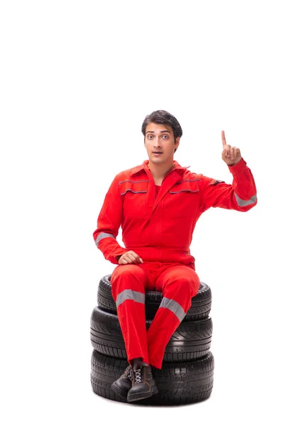 Young garage worker with tyre isolated on white — Stock Photo, Image