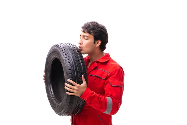 Joven trabajador de garaje con neumático aislado en blanco —  Fotos de Stock