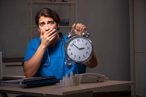 Joven médico guapo trabajando turno de noche en el hospital —  Fotos de Stock