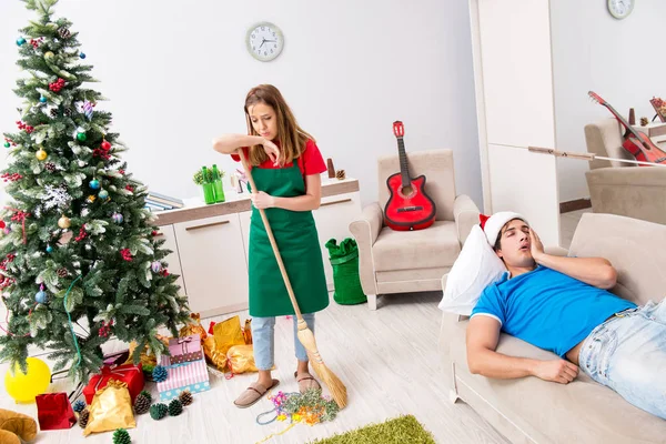 Noel partisinden sonra genç bir aile evi temizliyor. — Stok fotoğraf