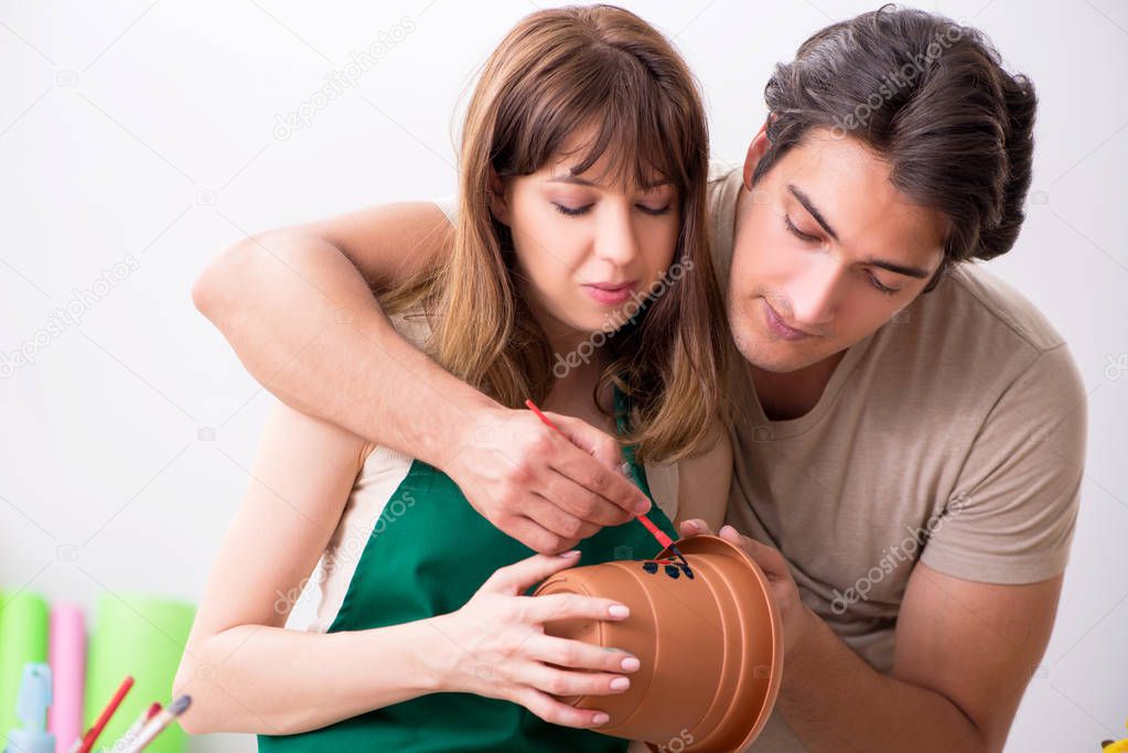 Couple decorating pots in workshop during class