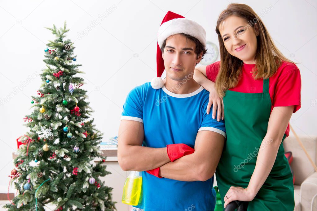 Young family cleaning apartment after christmas party