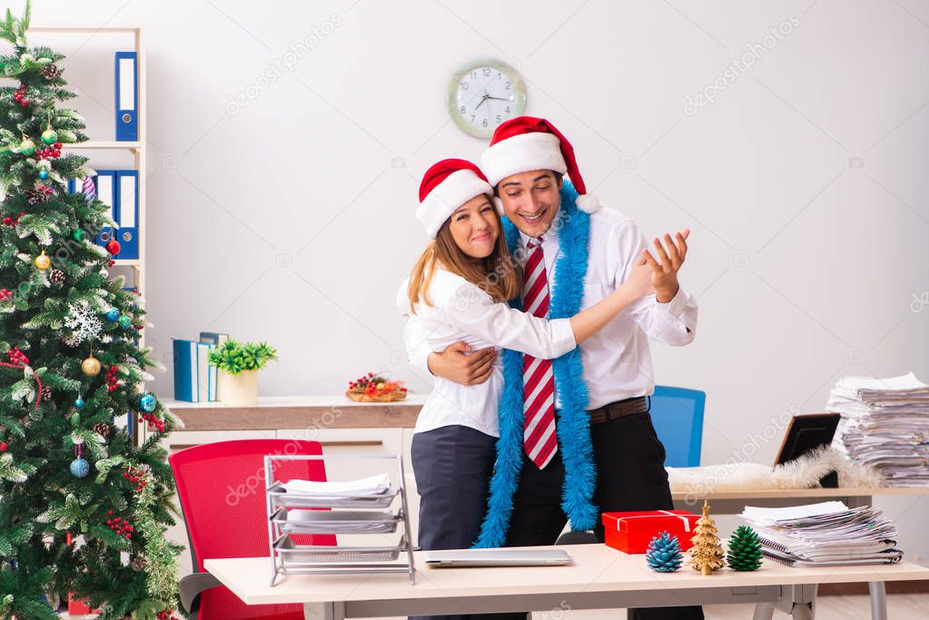Man and woman working at the office on Cristmass eve 