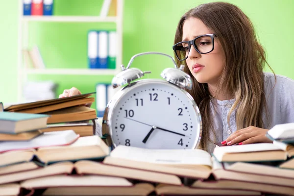 Giovane studentessa che si prepara per gli esami con molti libri in tempo — Foto Stock