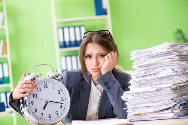 Jonge vrouwelijke werknemer zeer druk met lopende papierwerk in de tijd m — Stockfoto