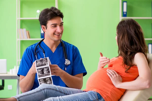 Беременная женщина, посещающая мужского гинеколога в клинике — стоковое фото