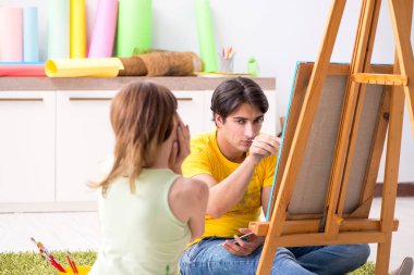 Evde resim yapmayı seven genç bir çift.