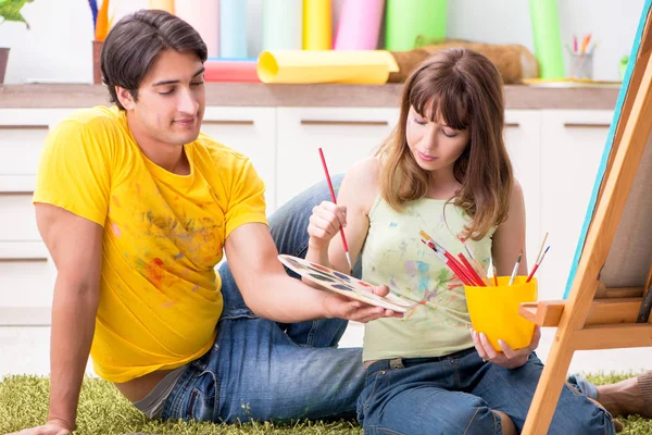 Jovem casal curtindo pintura em casa — Fotografia de Stock