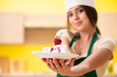 Genç aşçı mutfakta kek pişiriyor.