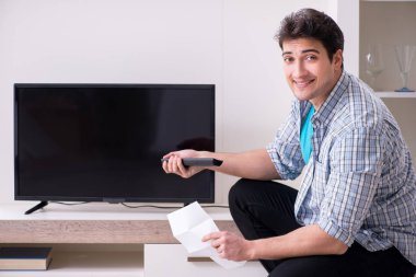 Bozuk televizyonu tamir etmeye çalışan adam