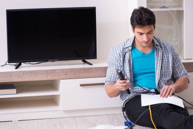 Bozuk televizyonu tamir etmeye çalışan adam