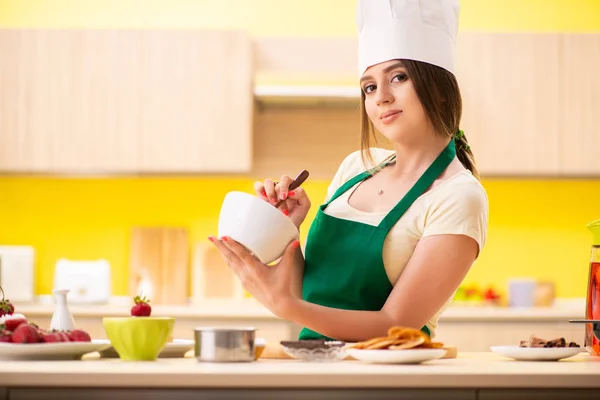 Mujer joven preparando ensalada en casa en la cocina — Foto de Stock