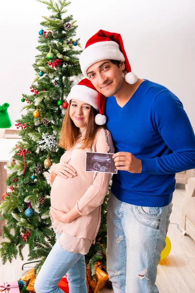 Żona w ciąży celevrating Boże Narodzenie z mężem — Zdjęcie stockowe