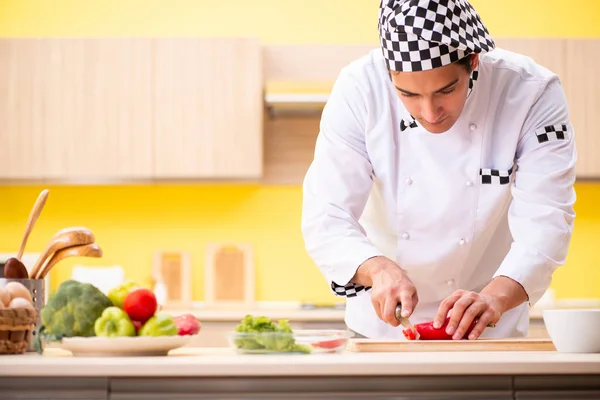 Young professional cook preparing salad at home — Stock Photo, Image