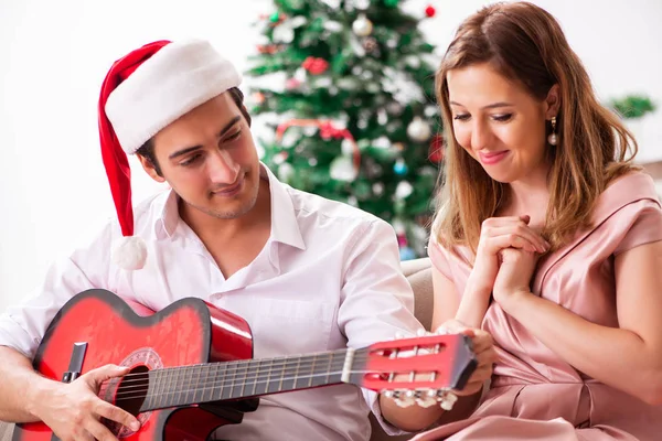 Young couple playing guitar at christmas — Stock Photo, Image