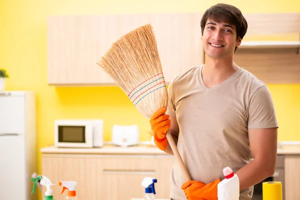 Single man cleaning kitchen at home