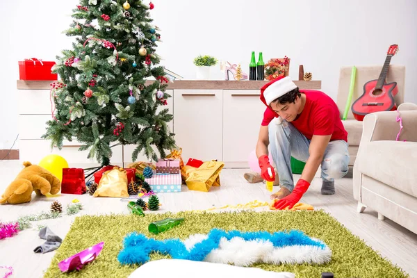 Hombre limpiando su apartamento después de la fiesta de Navidad —  Fotos de Stock