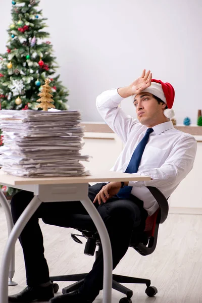 Jeune travailleur travaillant au bureau pendant le quart de Noël — Photo