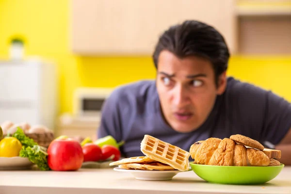 Az ember, akinek nehéz a választása az egészséges és egészségtelen ételek között — Stock Fotó