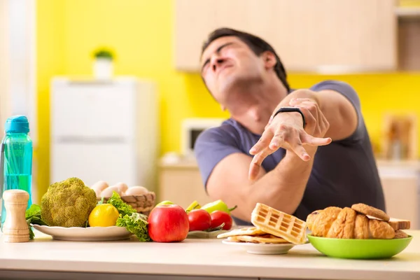 Människan har svårt att välja mellan hälsosam och ohälsosam mat — Stockfoto