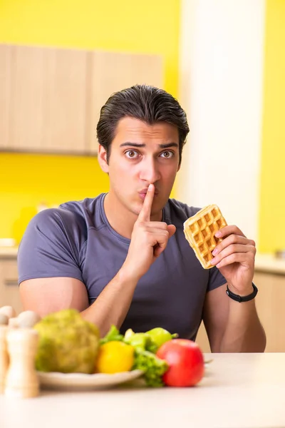 Hombre que tiene difícil elección entre la comida sana y no saludable —  Fotos de Stock