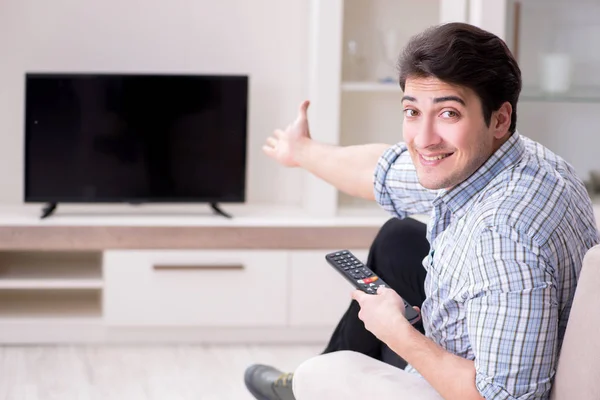 Jeune homme regardant la télévision à la maison — Photo