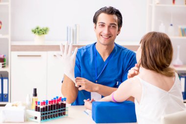 Kan testi örnekleme işlemi sırasında genç bir hasta.  