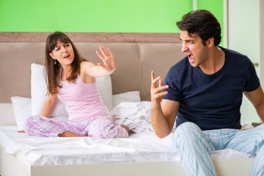 Woman and man in the bedroom during conflict clipart