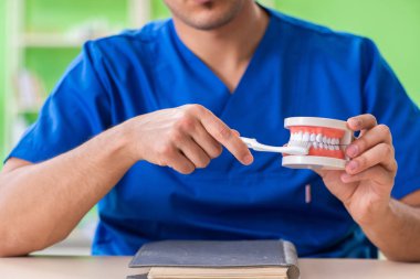 Erkek dişçi yeni diş implantı üzerinde çalışıyor. 