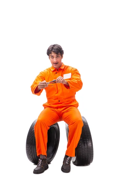 Young garage worker with tyre isolated on white — Stock Photo, Image