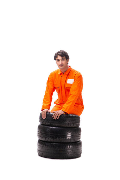 Young garage worker with tyre isolated on white
