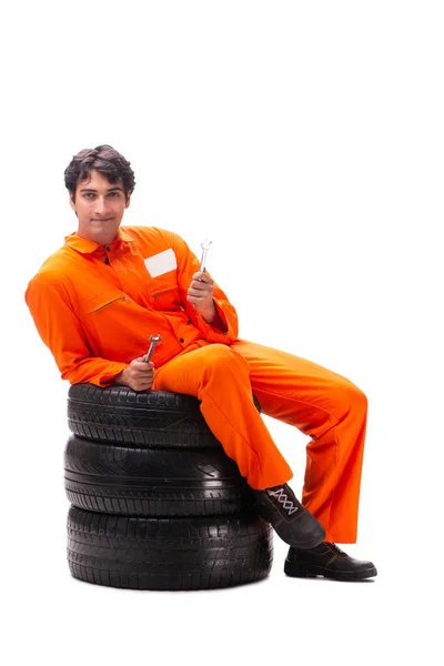 Young garage worker with tyre isolated on white — Stock Photo, Image