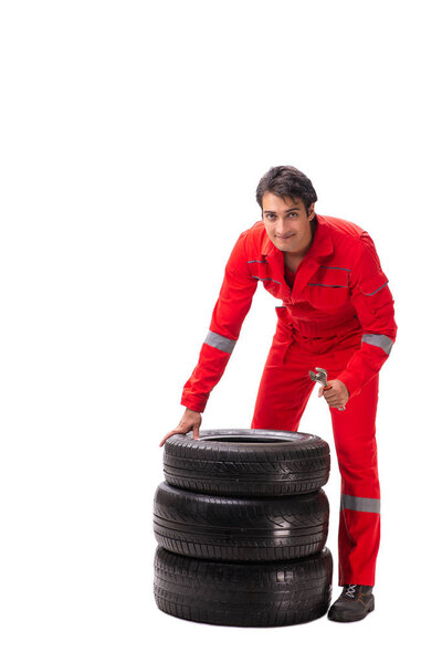 Young garage worker with tyre isolated on white