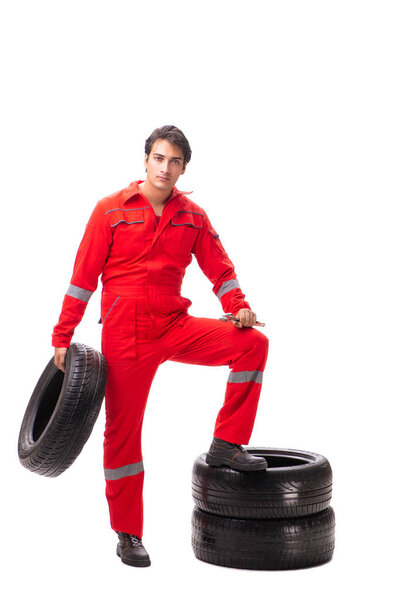 Young garage worker with tyre isolated on white