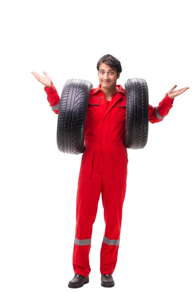 Young garage worker with tyre isolated on white — Stock Photo, Image