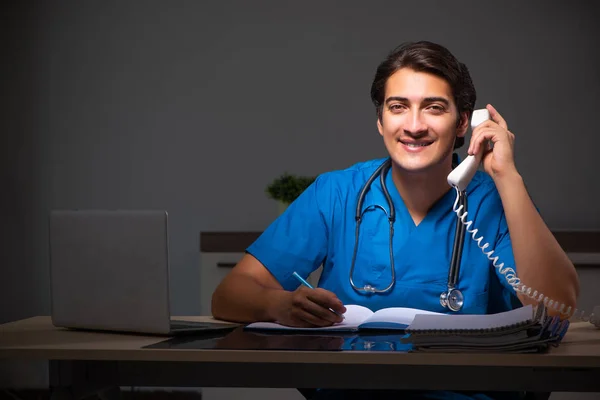 Hastanede gece vardiyasında çalışan yakışıklı genç bir doktor. — Stok fotoğraf