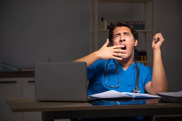 Joven médico guapo trabajando turno de noche en el hospital — Foto de Stock