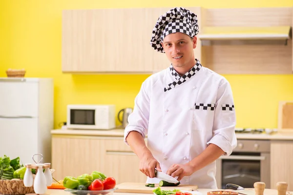 Young professional cook preparing salad at kitchen — Stock Photo, Image